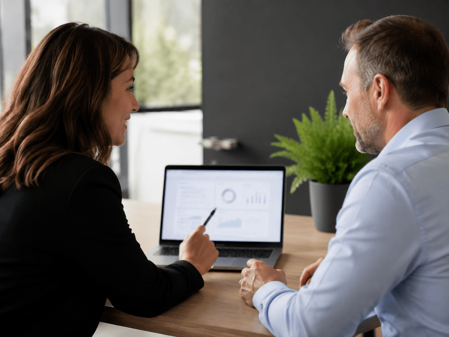 Advisor and business owner reviewing an abstract financial reporting dashboard